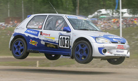 Morten Jespersen passerer det berømte 'jump' på Höljes-banen i sikker konkurrencestil med sin Peugeot 106 MAXI.
